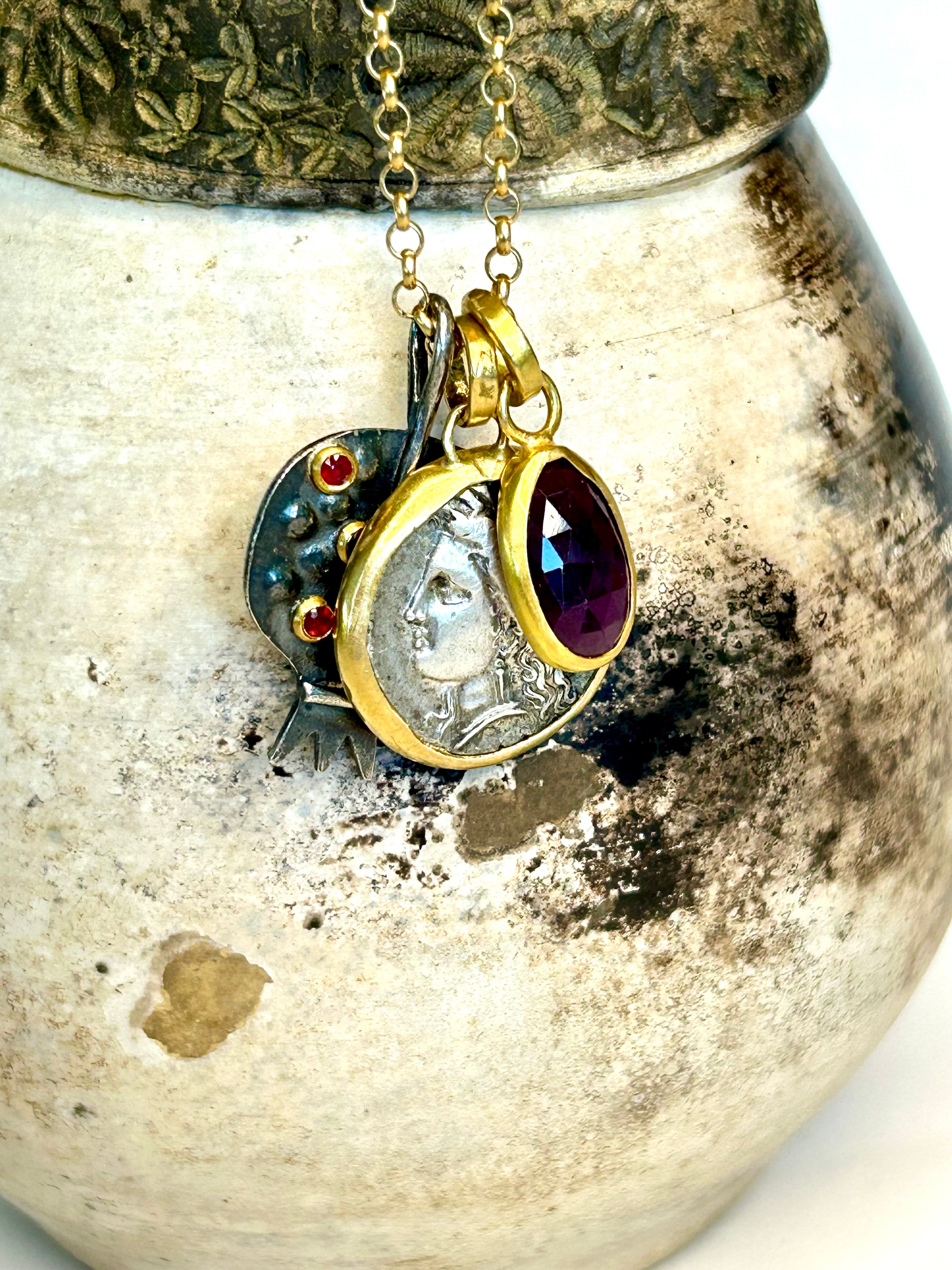 Necklace with a pendant featuring a coin and gemstones on a textured surface
